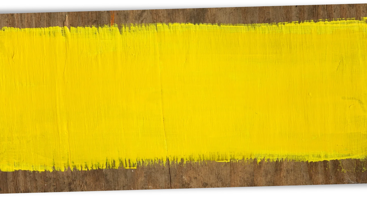 Decorative background of a piece of wood with yellow paint